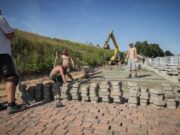 В будущем ландшафтном парке на Стрелке укладывают плитку вдоль берега