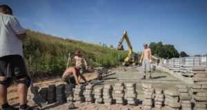 В будущем ландшафтном парке на Стрелке укладывают плитку вдоль берега